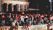 Jubelnde Menschen auf der Berliner Mauer am Brandenburger Tor. © dpa - Fotoreport Foto: Lehtikuva Oy