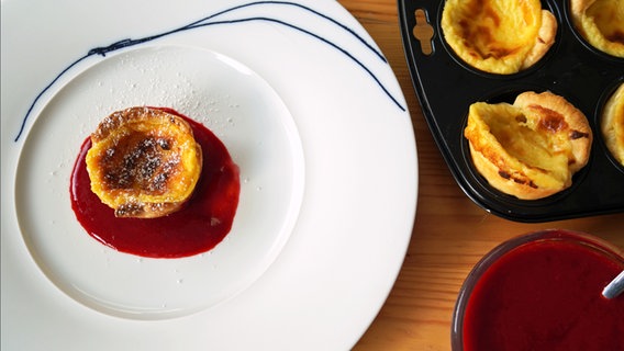Portugiesische Puddingtörchen mit Soße auf einem Teller serviert. © NDR Foto: Florian Kruck