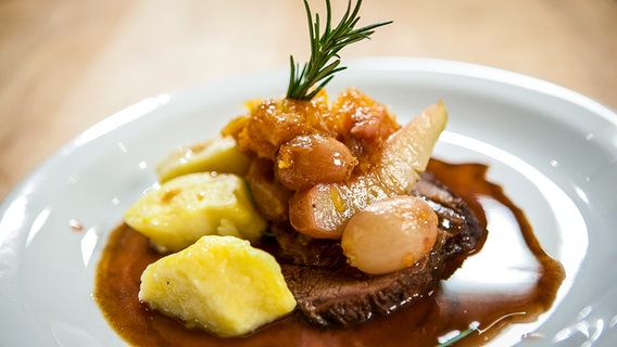 Geschmorte Wildschweinkeule mit Rotwein-Früchten und Gnocchi serviert. © NDR Foto: Florian Kruck
