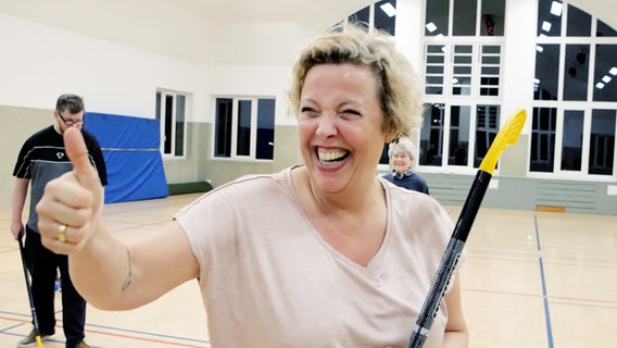 Andrea H. steht auf dem Hockeyfeld, Daumen hoch, und strahlt in die Kamera. © NDR Foto: Moritz Schwarz/Oliver Zydek