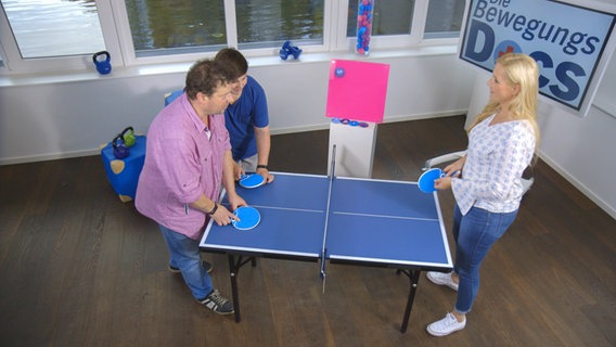 Bewegungs-Doc Melanie Hümmelgen spielt Tischtennis mit einem Vater und seinem Sohn. © NDR Foto: Moritz Schwarz/Oliver Zydek