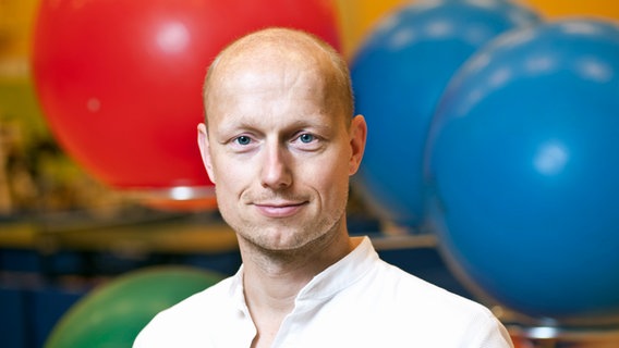 Porträt von Dr. Helge Riepenhof, im Hintergrund ein Gymnastikraum. © Jens Jarmer/BG Klinikum Hamburg 