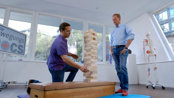 Arzt und Patient bauen einen Holzklotz-Turm. © NDR/nonfictionplanet 