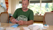 Ein Mann nimmt Tabletten aus der Packung. © NDR/nonfictionplanet 