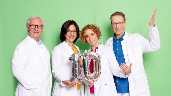 Die Ernährungs-Docs Dr. Klasen, Schäfer, Andresen und Riedl posieren mit Luftballons in Form einer silbernen Zehn. © NDR Foto: Claudia Timmann