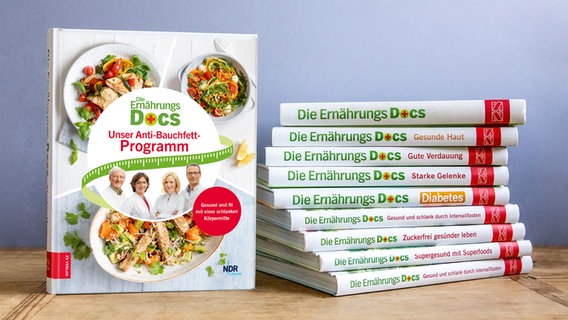 Many Nutrition Docs books are stacked on a table, with the latest book next to them.  © NDR Photo: Claudia Timmann