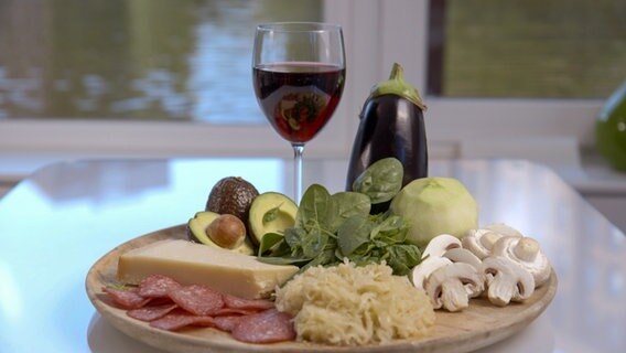 Histaminhaltiges auf einem Teller: Sauerkraut, Pilze, Salami, Avocado, Aubergine, auch ein Glas Rotwein. Histaminhaltiges auf einem Teller: Sauerkraut, Pilze, Salami, Avocado, Aubergine, auch ein Glas Rotwein. © NDR Foto: Moritz Schwarz/Oliver Zydek