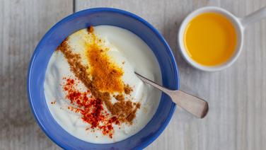 Joghurt mit bunten Gewürzen, daneben ein Schälchen Leinöl. © NDR Foto: Claudia Timmann