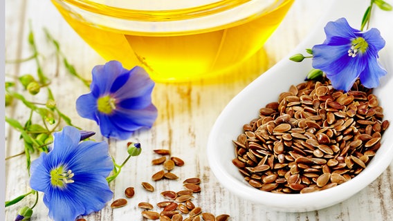 Linseed oil and linseed on a wooden table.  © Fotolia.com Photo: cropped