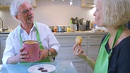 E-Doc Jörn Klasen bietet seiner Patientin aus einer Dose Kekse an. © NDR 