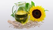 Eine Karaffe mit Öl, eine Sonnenblume und Sonnenblumenkerne © Fotolia.com Foto: photocrew