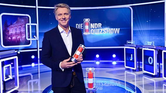Jörg Pilawa steht im Studio der NDR Quizshow und hält die Trophäe "Die Leuchte des Nordens" in der Hand. © NDR/Uwe Ernst Foto: Uwe Ernst