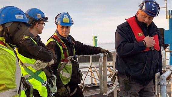 Sven Fischer koordiniert sein Team an Land und gibt über Funk Anweisungen an das Team auf dem Schiff. Sven Fischer koordiniert sein Team an Land und gibt über Funk Anweisungen an das Team auf dem Schiff. © NDR/Doclights GmbH/Emanuela Casentini