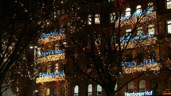 Industriekletterer bringen die Leuchtbänder an der Fassade des Alsterhauses an. © NDR 