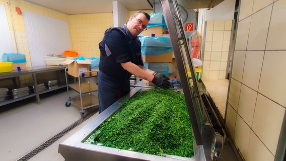 Chefkoch Kevin Haarweg bereitet 330 kg tiefgefrorenen Grünkohl für die Kohlfahrt zu. © NDR / Nadja Kölling 