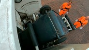 Die Schüttung hebt die Behälter automatisch dank Sensortechnik. Ein Haltemechanismus verhindert, dass die ganze Tonne ins Fahrzeug fällt. © NDR/FILMBLICK/Timo Hayen 