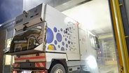 Diese Straßenkehrmaschine verliert Öl. Damit der Mitarbeiter aha-Werkstatt das Leck finden kann, muss die Maschine vor der Reparatur in die Waschstraße. © NDR/FILMBLICK/Christina Georgi 