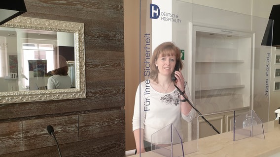 Front Office Managerin Carolin Knöfler kontaktiert Gäste vor der Anreise, um die aktuellen Regelungen zu erläutern. © NDR/AP Clipfilm 