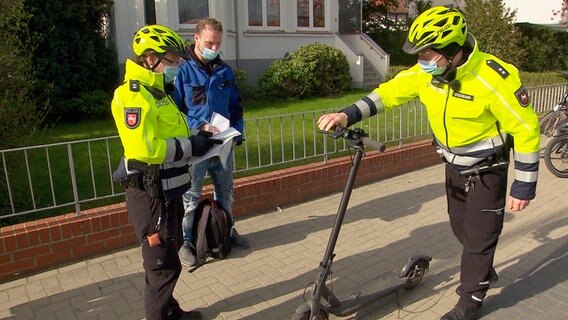 Auch E-Scooter müssen verkehrssicher sein. Die Beamten der Fahrrad-Polizei haben den Fahrer wegen defekter Bremsen angehalten. © NDR/Kamera Zwei 
