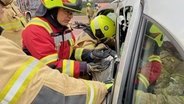 Autowracks öffnen unter Anleitung. © NDR/ADAMfilm 