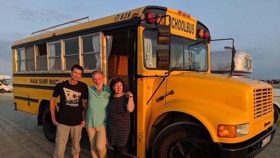 Doris und Michael stehen mit ihrem Freund Andre vor dem Schulbus. © NDR 