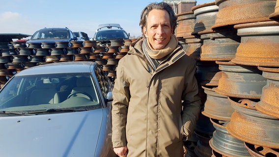 Jo Hiller deckt die Tricks rund ums Auto auf. Auf dem größten Schrottplatz Deutschlands spricht er mit Autofans. © NDR/Christian Lang 
