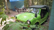 Ein grüner Trabi, der stark modifiziert ist, steht im Jahr 2019 auf einem Campingplatz. © NDR 