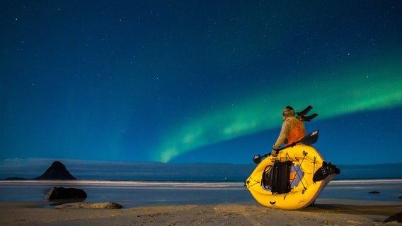 Kameramann Rick Rosenthal benutzt ein aufblasbares Kajak um sich leise den Walen nähern zu können. Für die Dreharbeiten war er auch in Bleik, Norwegen, wo das Nordlicht den Nachthimmel verzauberte. © NDR/doclights/TMFS/Wild Logic 