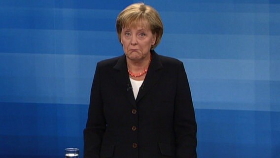 Angela Merkel guckt verdutzt in die Kamera.  