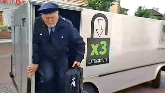 Ein Mann in Uniform steigt aus dem X3-Datenpanzerwagen  