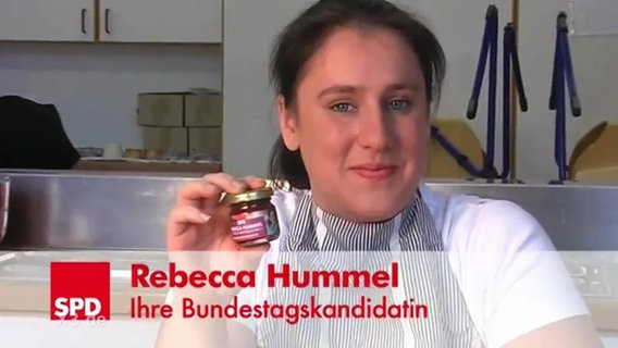 Die SPD-Bundestagskanditatin Rebecca Hummel hält ein Glas Marmelade in der Hand.  