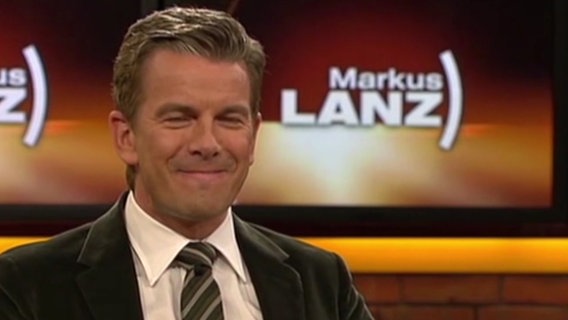Markus Lanz grinst vor einem Logo seiner Talkshow. © NDR Foto: Screenshot