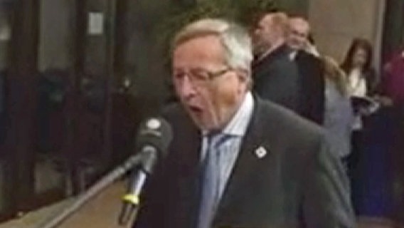 Jean-Claude Juncker versucht in ein Mikrofon zu beißen.  Foto: Screenshot