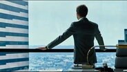 Ein Mann steht an einem Fenster und blickt auf ein Hochhäusermeer. © NDR Foto: Screenshot