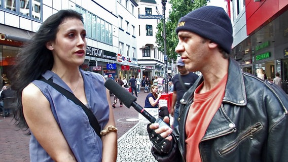 Eine Passantin spricht mit extra 3 Reporter Rollo in einer Fußgängerzone. © NDR Foto: Screenshot