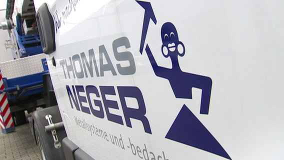 Logo der Firma Thomas Neger, das einen stilisierten Schwarzen mit dicken Lippen und weiten Ohrlöchern zeigt.  