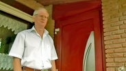 Mann vor einer roten Tür  