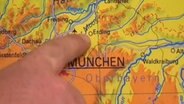 Ein Finger auf einer Karte zeigt auf Erding bei München © NDR 
