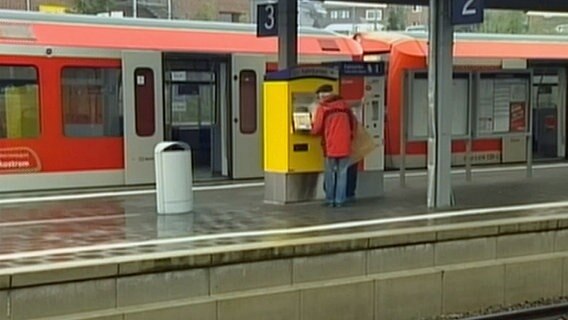 Ein Mann steht am Fahrkartenautomat  