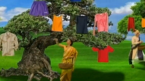 Bunte Kleidungsstücke hängen an einem Baum  
