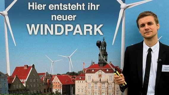 Tobias Schlegl mit Plakat zur Windkraftanlage © NDR 