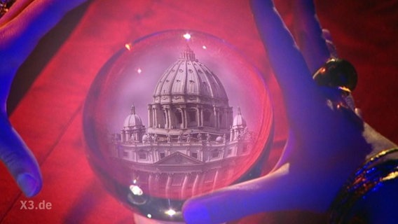 Eine Glaskugel zeigt die Kuppel des Petersdom.  