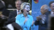 Ursula von der Leyen auf einer Parteiveranstaltung der CDU klatscht ekstatisch in die Hände.  