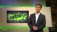 Christian Ehring vor dem Logo der Sendung "Extra 3".  