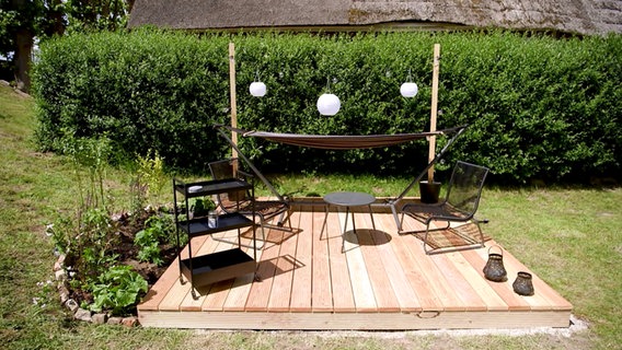 Eine kleine Holzterrasse dient als Sitzecke im Garten. © NDR/nonfiction planet 
