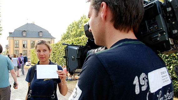 Kameraassistentin hält dem Kameramann eine weiße Karte hin  Foto: Christian Wütschner