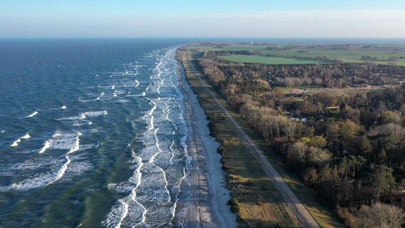 Luftaufnahme vom Birkemose Strand an der Südspitze Dänemarks. Von links brechen die Wellen am Sand. Rechts führt eine Straße parallel zum Strand. Dahinter ist ein Wald mit Grünflächen.  Foto: Franziska Husmann