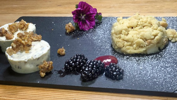 Walnuss-Grillage, Birnenstreusel und Brombeeren auf einer Schieferplatte serviert. © megaherz 