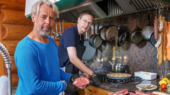 Beim Kochen bekommt Henning Bauck Unterstützung von seinem Freund Thorsten. © NDR/Doclights/Marc Vorwerk 