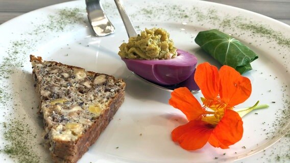 Rote Eier mit Lupinen-Hummus gefüllt und Lupinen-Eiweißbrot auf einem Teller angerichtet. © megaherz 